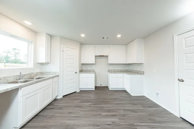 a kitchen with granite countertop white cabinets and white appliances