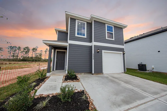 a front view of a house with a yard and garage