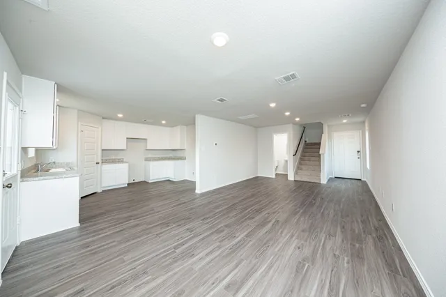 a view of a kitchen with wooden floor and a window
