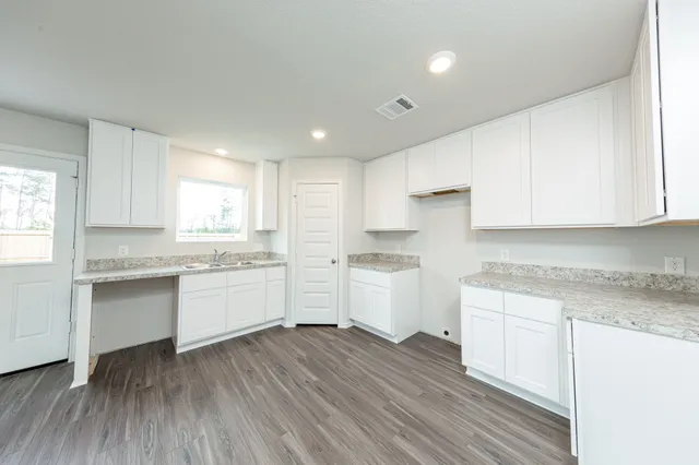 a kitchen with granite countertop white cabinets and white appliances