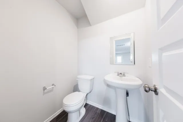 a bathroom with a toilet sink and mirror