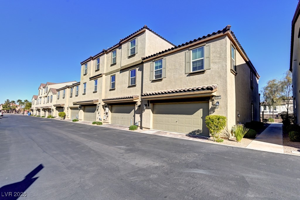 1284 Arcadia Rim Place Henderson, NV 89002 - Photo 4 of 27 View of front of house with stucco siding, an attached garage, a residential view, and a tiled roof