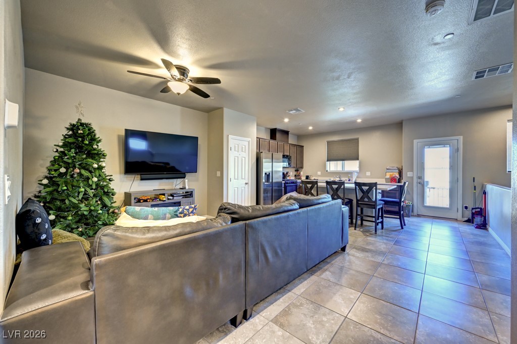 1284 Arcadia Rim Place Henderson, NV 89002 - Photo 5 of 27 Living room featuring a ceiling fan, light tile patterned flooring, a textured ceiling, and recessed lighting