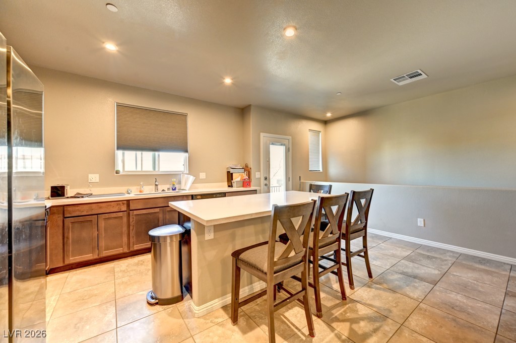 1284 Arcadia Rim Place Henderson, NV 89002 - Photo 9 of 27 Kitchen featuring wood finish cabinets, light countertops, freestanding refrigerator, a kitchen breakfast bar, and recessed lighting