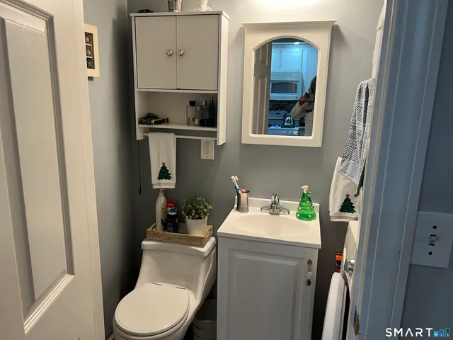 a bathroom with a toilet a sink and mirror