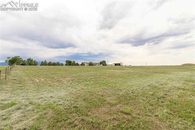 11170 Peaceful Valley Road Colorado Springs, CO 80925 - Photo 40 of 49 View of green lawn featuring a rural view