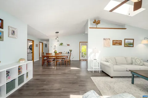 a living room with furniture and a dining table with kitchen view