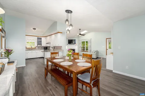 a view of a dining room and livingroom with furniture wooden floor a chandelier