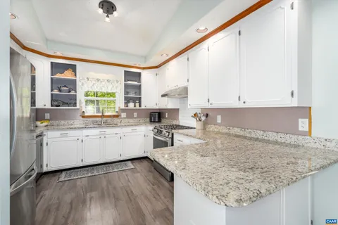 a kitchen with granite countertop white cabinets and white appliances