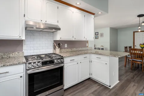 a kitchen with granite countertop wooden cabinets stainless steel appliances and a counter space