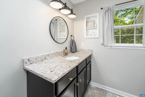 a bathroom with a granite countertop sink and a mirror