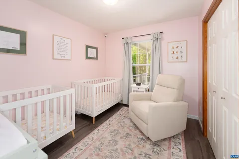 a living room with furniture and a baby crib