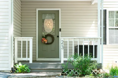 a front view of a house with a large window and potted plants
