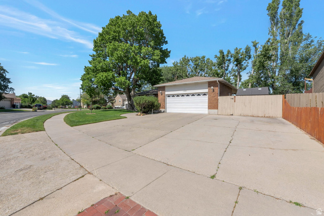 11072 Windy Peak Ridge Drive, Unit 32 Sandy, UT 84094 - Photo 2 of 30 Brick exterior featuring an attached two-car garage, concrete driveway, and side yard access