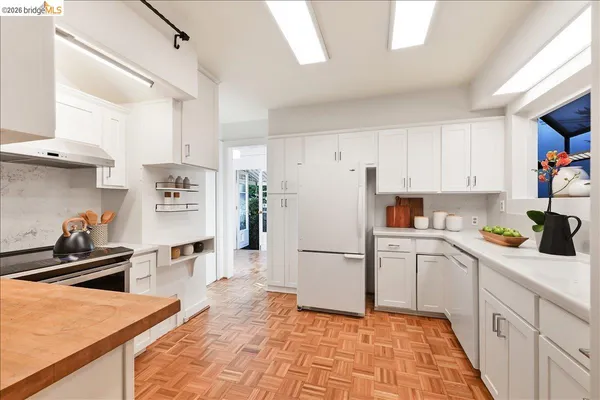 a kitchen with granite countertop a refrigerator stove top oven and sink