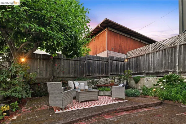 a view of outdoor sitting area with furniture and wooden fence
