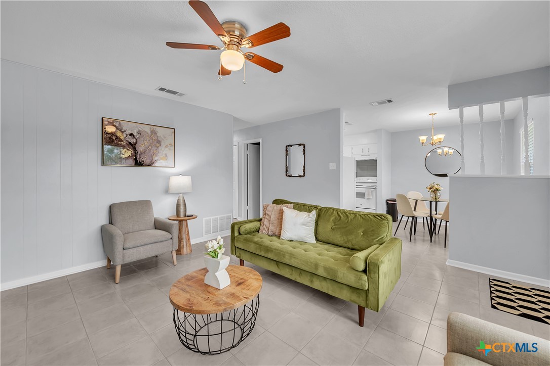 a living room with furniture and a view of kitchen