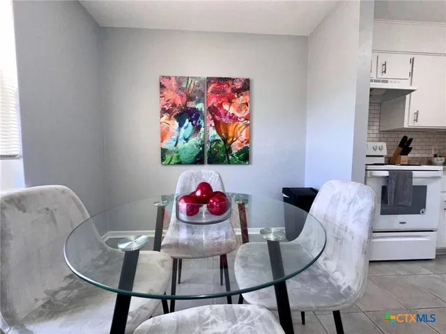 a living room with furniture a rug and white walls