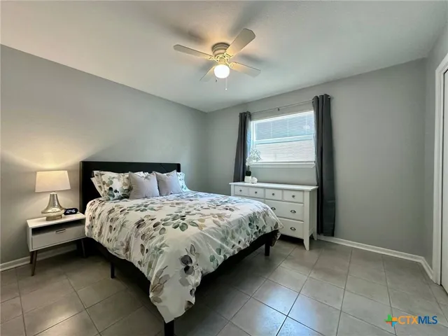 a bedroom with a bed and a ceiling fan