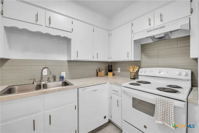 a kitchen with cabinets appliances a sink and a cabinets