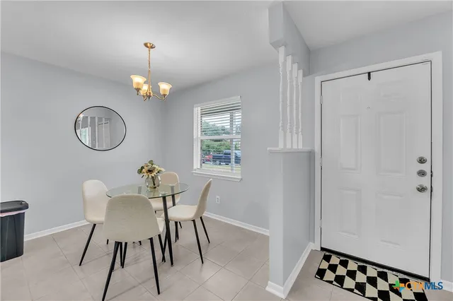 a view of a dining room with furniture a chandelier and wooden floor