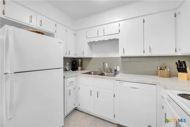 a kitchen with white cabinets and white appliances