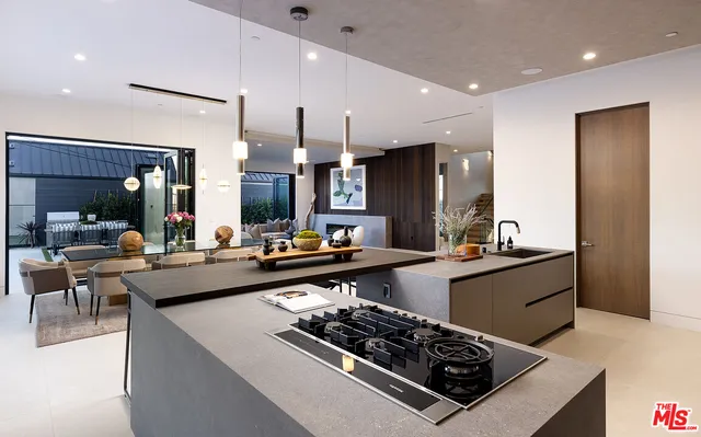 a kitchen with stainless steel appliances a stove a sink dishwasher and a refrigerator with wooden floor