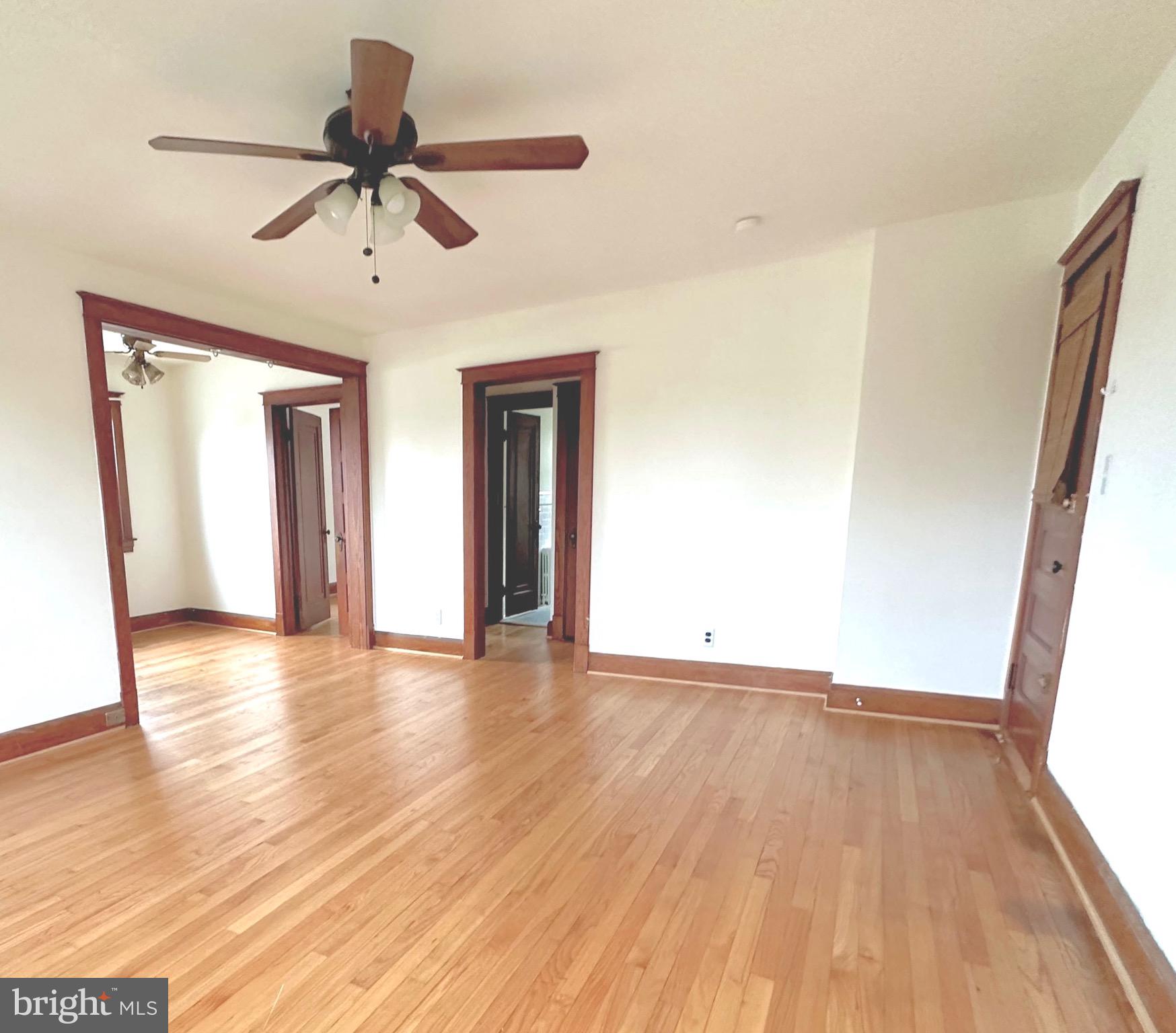 8000 Harford Road Parkville, MD 21234 - Photo 3 of 20 a view of an empty room with wooden floor and a window