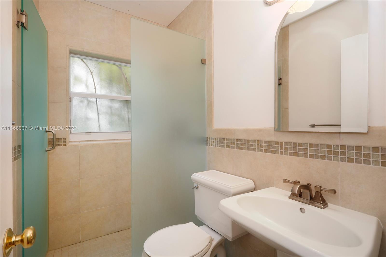 6970 Sunset Drive Miami, FL 33143 - Photo 11 of 30 a bathroom with a sink mirror and toilet