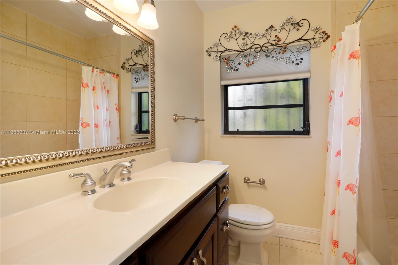 6970 Sunset Drive Miami, FL 33143 - Photo 13 of 30 a bathroom with a sink vanity mirror and toilet