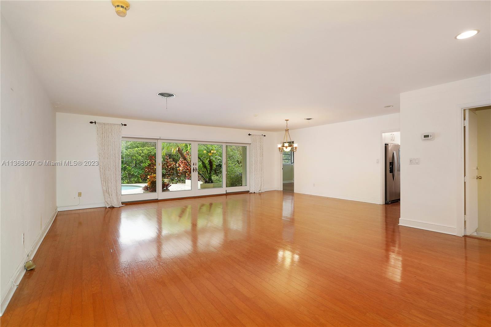 6970 Sunset Drive Miami, FL 33143 - Photo 3 of 30 a view of empty room with wooden floor and fan