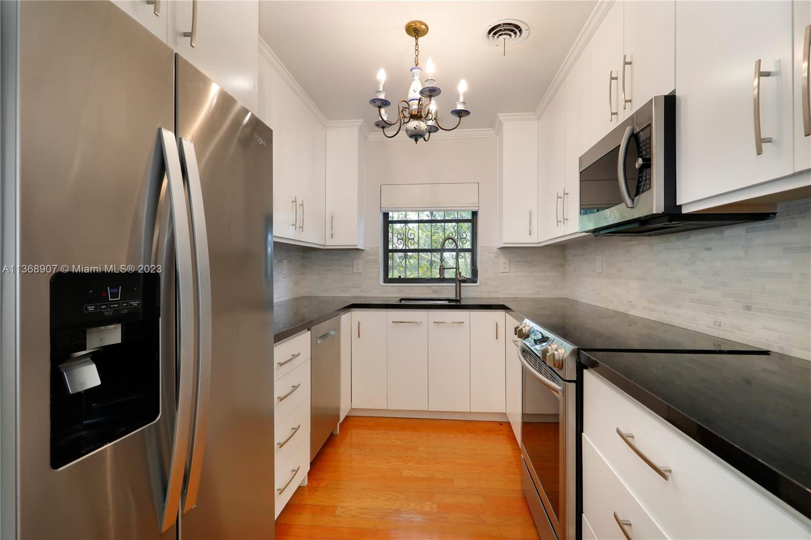 6970 Sunset Drive Miami, FL 33143 - Photo 6 of 30 a kitchen with stainless steel appliances granite countertop a refrigerator a oven a sink and dishwasher