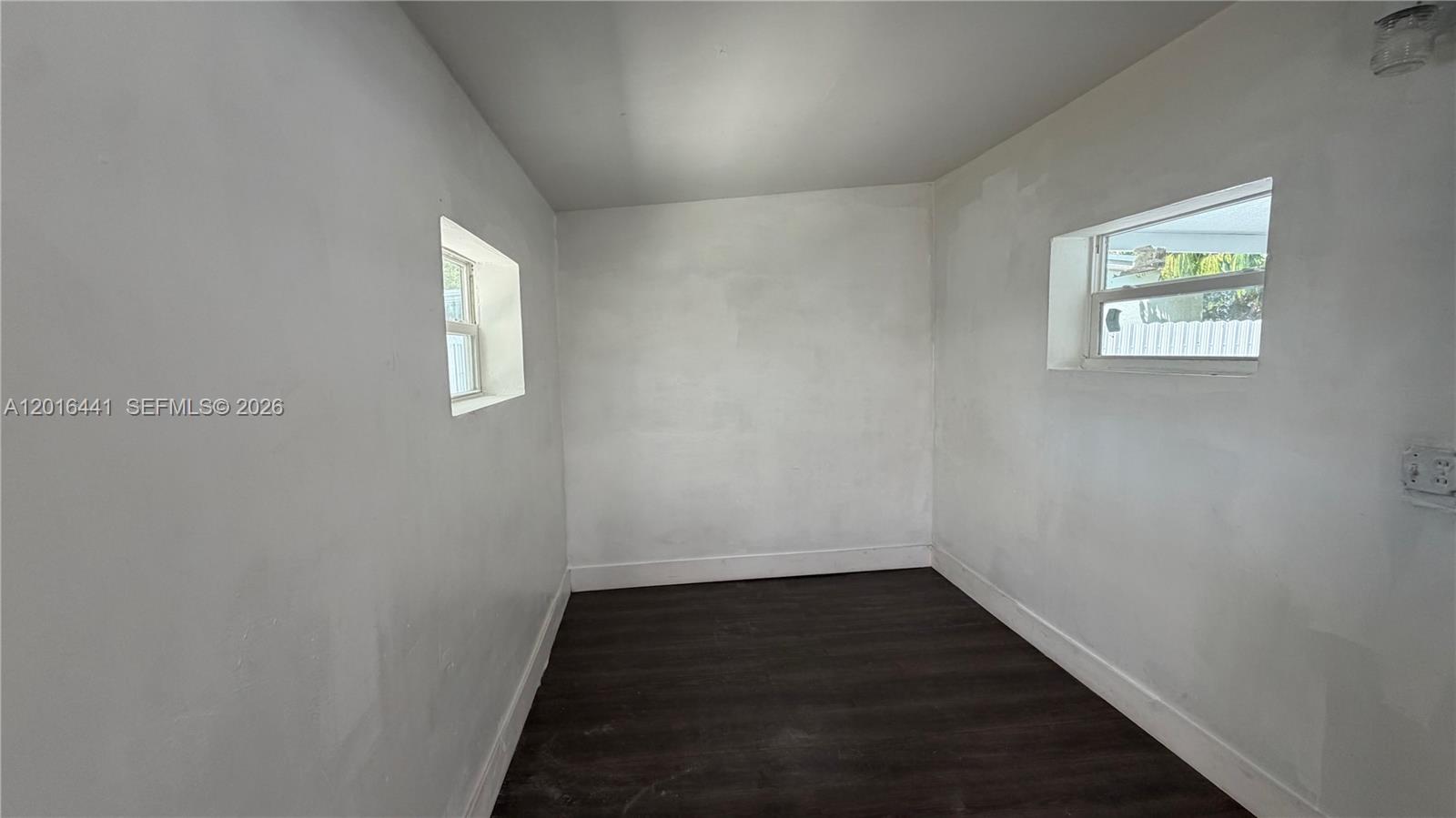 2230 Service Road Opa-Locka, FL 33054 - Photo 15 of 25 a view of an empty room with wooden floor and a window