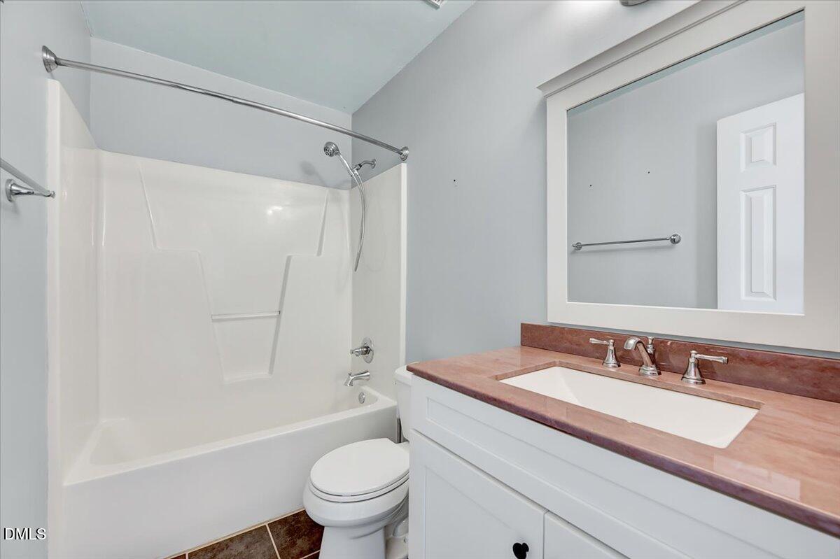 1716 Middle Ridge Drive Willow Spring, NC 27592 - Photo 24 of 41 a bathroom with a granite countertop sink a toilet and a bathtub