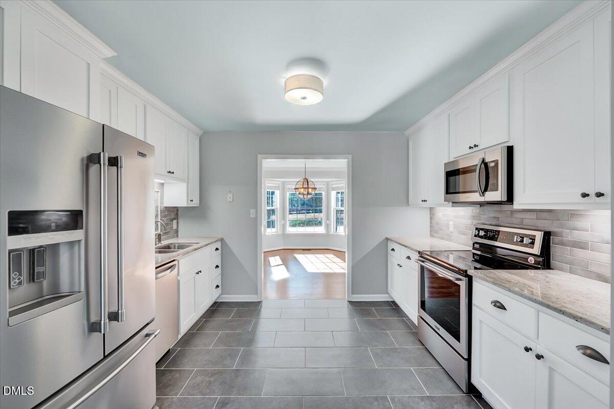 1716 Middle Ridge Drive Willow Spring, NC 27592 - Photo 8 of 41 a kitchen with stainless steel appliances granite countertop a refrigerator stove and sink
