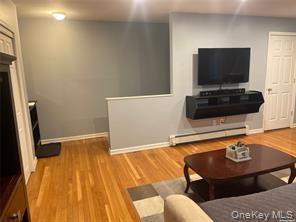 263 River Avenue, Unit 6AU Patchogue, NY 11772 - Photo 6 of 12 a living room with furniture and a flat screen tv