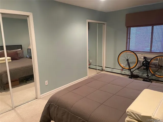a bedroom with a bed and dresser with mirror