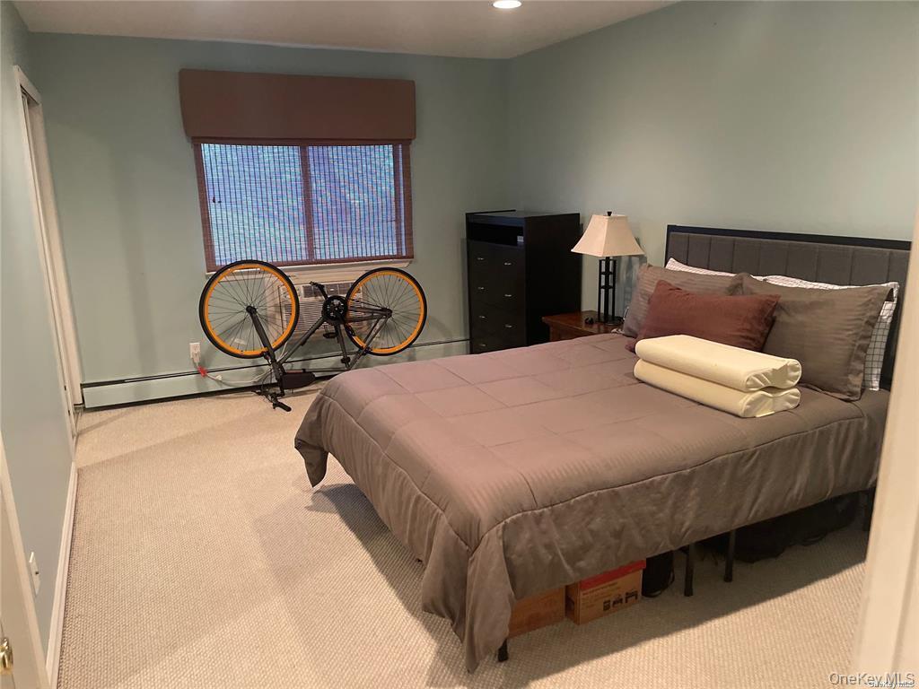 263 River Avenue, Unit 6AU Patchogue, NY 11772 - Photo 10 of 12 a bedroom with a bed and dresser with mirror