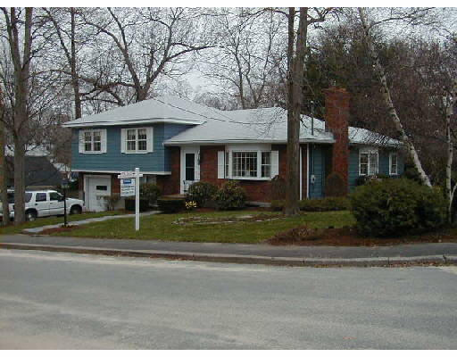a view of a house with a garden and trees