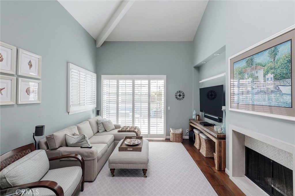 1 Santa Rosa Court Manhattan Beach, CA 90266 - Photo 3 of 28 a living room with furniture a flat screen tv and a floor to ceiling window