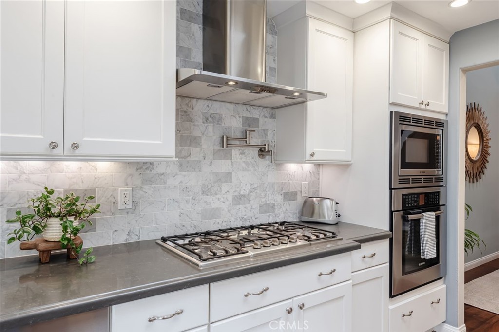 1 Santa Rosa Court Manhattan Beach, CA 90266 - Photo 8 of 28 a kitchen with granite countertop a stove and cabinets