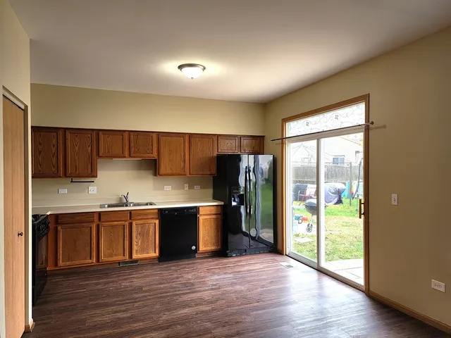 a large kitchen with stainless steel appliances granite countertop a refrigerator and a sink