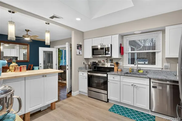 a kitchen with granite countertop a sink stainless steel appliances and cabinets