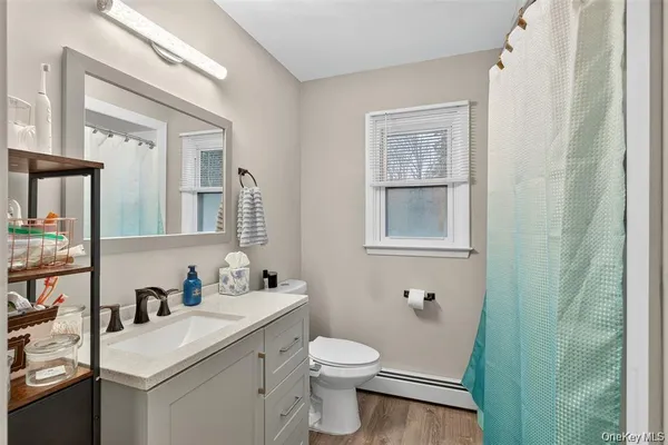 a bathroom with a sink vanity mirror and toilet