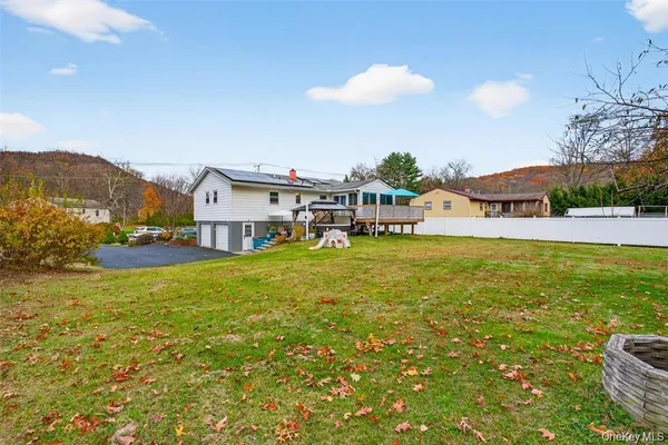 a view of a house with a big yard and large trees