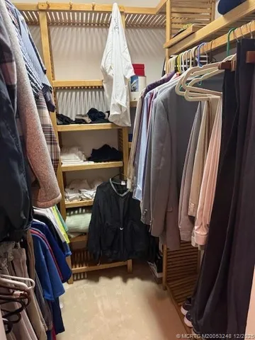 a view of walk in closet with clothes and shoes