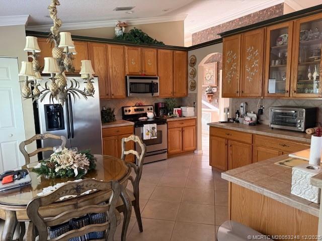 6948 Southeast Twin Oaks Circle Stuart, FL 34997 - Photo 5 of 24 a kitchen with stainless steel appliances granite countertop a stove top oven a sink dishwasher a dining table and chairs with wooden floor