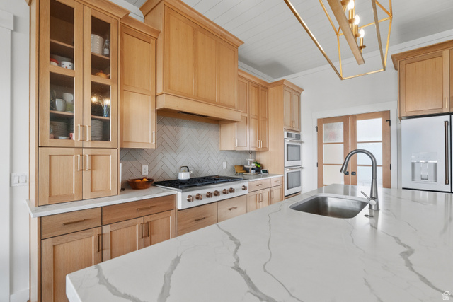 2013 South 100 West Perry, UT 84302 - Photo 16 of 49 Spacious kitchen featuring a large island with an undermount sink, light wood cabinetry, white countertops, built-in double ovens, and a gas range with a herringbone tile backsplash