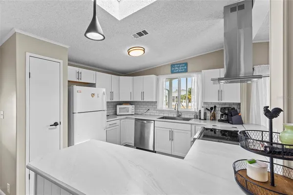 a kitchen with stainless steel appliances kitchen island granite countertop a refrigerator and a stove