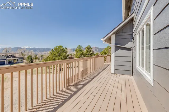 a view of a balcony with wooden floor and fence